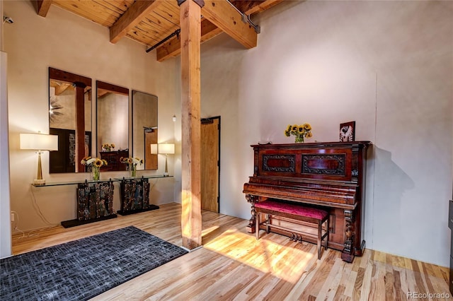 miscellaneous room with a high ceiling, light hardwood / wood-style flooring, wooden ceiling, and beam ceiling