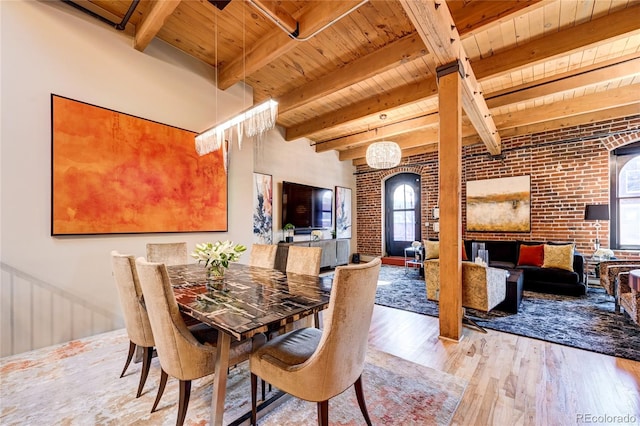 dining room featuring light hardwood / wood-style floors, plenty of natural light, and brick wall