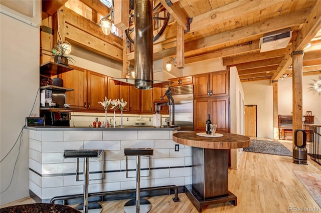 kitchen featuring backsplash, light wood-type flooring, beamed ceiling, kitchen peninsula, and wood ceiling