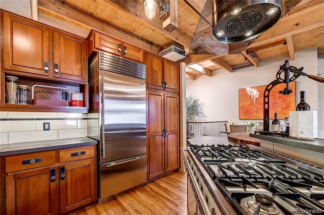 kitchen with appliances with stainless steel finishes, light wood-type flooring, beam ceiling, and wood ceiling