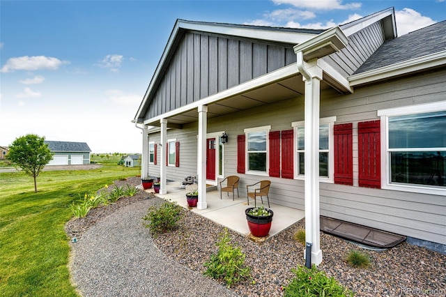 196 W 8th Ave, Byers, CO 80103 - property entrance featuring board and batten siding, a lawn, a patio, and roof with shingles