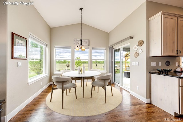 196 W 8th Ave, Byers, CO 80103 - dining space with a chandelier, dark wood-style flooring, vaulted ceiling, and baseboards