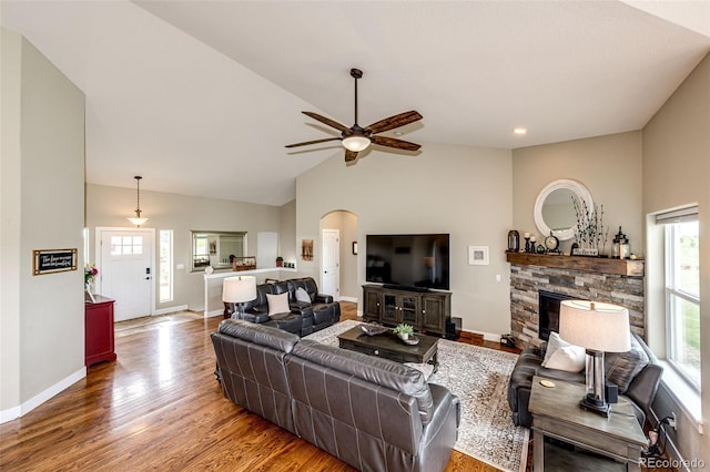 196 W 8th Ave, Byers, CO 80103 - living area featuring plenty of natural light, a ceiling fan, wood finished floors, high vaulted ceiling, and a stone fireplace