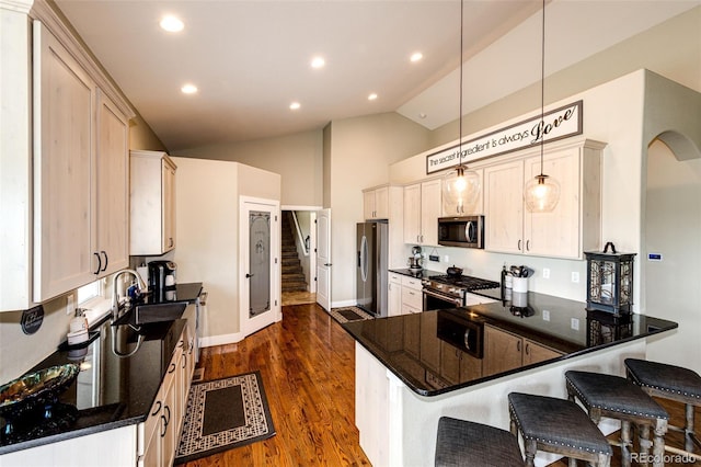 196 W 8th Ave, Byers, CO 80103 - kitchen featuring appliances with stainless steel finishes, a peninsula, dark wood-type flooring, a breakfast bar area, and baseboards