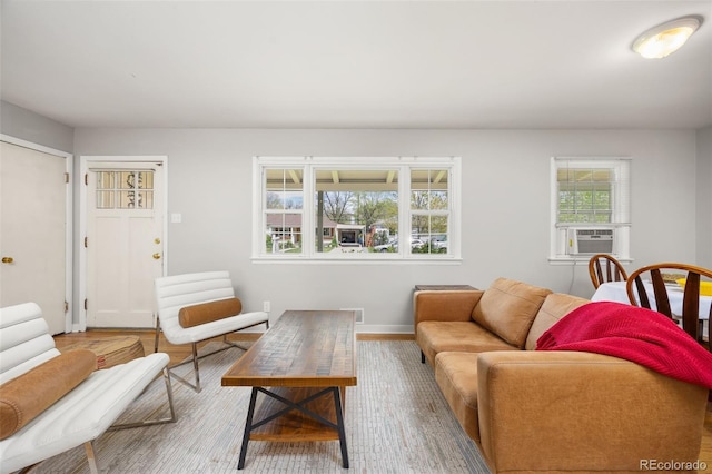 living area featuring wood finished floors, cooling unit, and baseboards