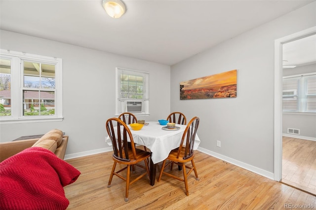 dining space with light wood-type flooring and baseboards