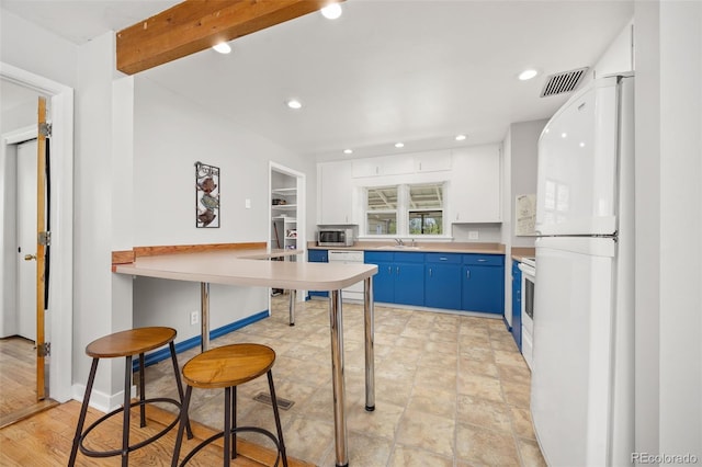 kitchen with blue cabinetry, white appliances, a sink, recessed lighting, and light countertops
