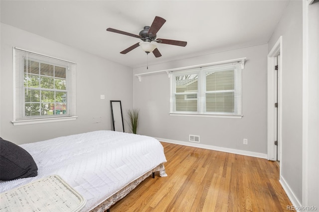 bedroom with wood finished floors, baseboards, and a ceiling fan