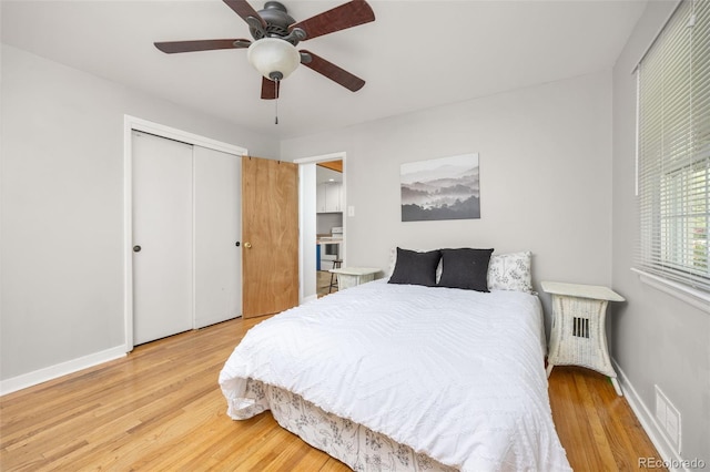 bedroom featuring wood finished floors, a closet, baseboards, and a ceiling fan