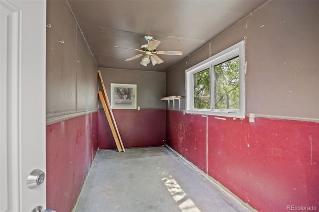 spare room featuring unfinished concrete floors and a ceiling fan