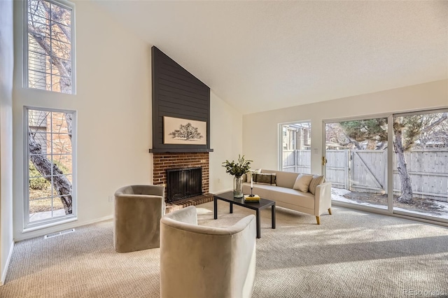 living room featuring high vaulted ceiling, a fireplace, and light carpet