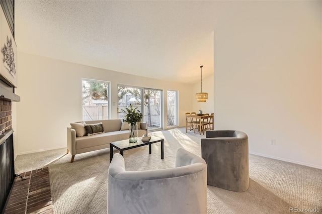 living room featuring a textured ceiling, vaulted ceiling, carpet, and a fireplace