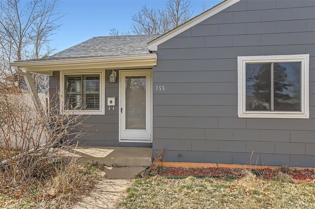 property entrance with a porch and roof with shingles