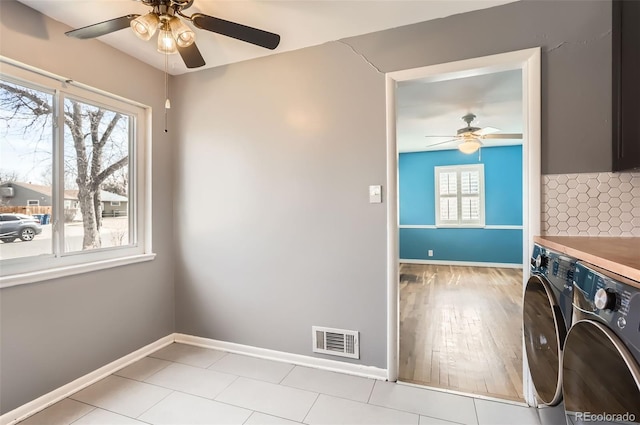 laundry area with baseboards, visible vents, laundry area, ceiling fan, and washing machine and dryer