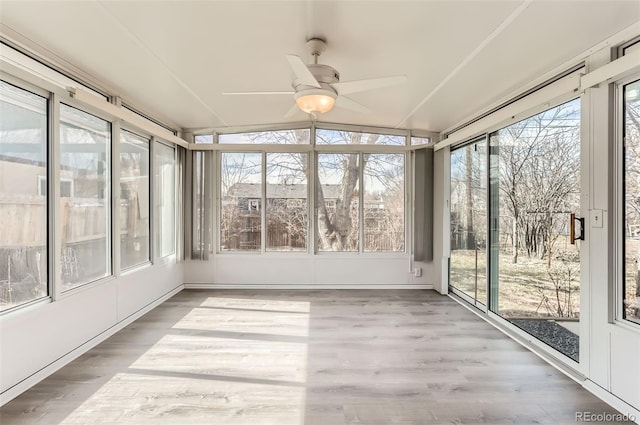 unfurnished sunroom with vaulted ceiling and a ceiling fan