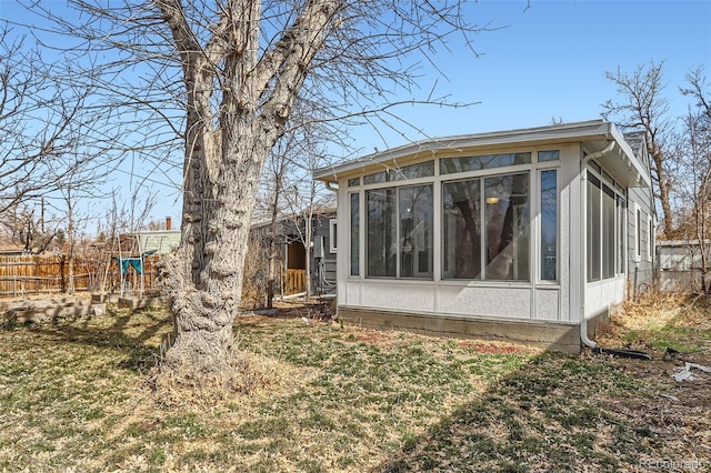 back of property featuring fence and a sunroom