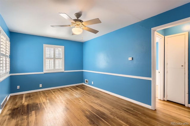 spare room with hardwood / wood-style flooring, ceiling fan, and baseboards