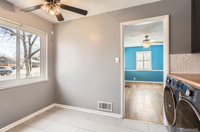 laundry room featuring a ceiling fan, washing machine and clothes dryer, and baseboards