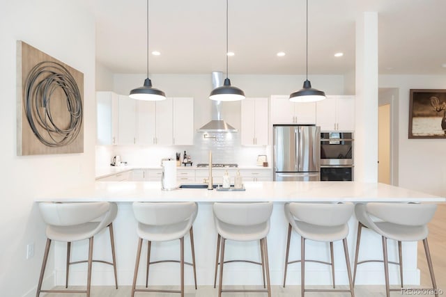 kitchen with appliances with stainless steel finishes, decorative light fixtures, and white cabinets