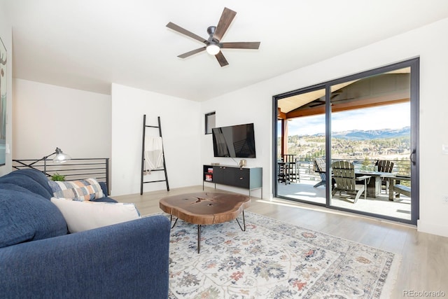 living room with ceiling fan and light wood-type flooring