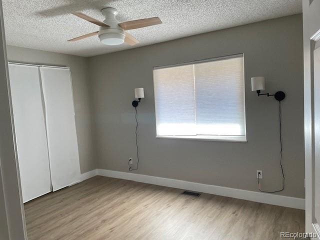 1415 Bacchus Dr Unit D9, Lafayette, CO 80026 - unfurnished bedroom with wood finished floors, a closet, a textured ceiling, and a ceiling fan