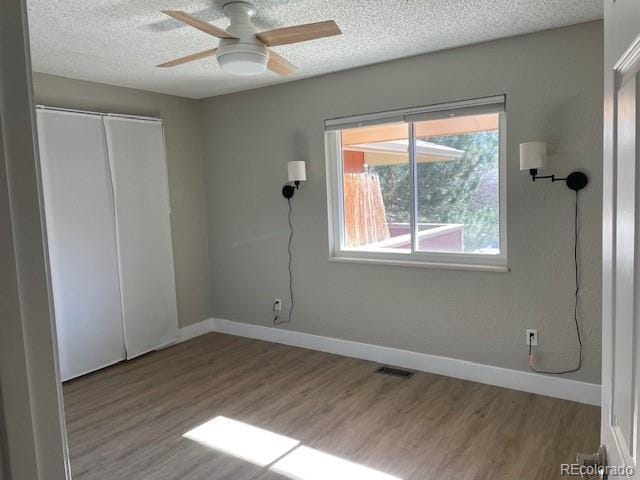 1415 Bacchus Dr Unit D9, Lafayette, CO 80026 - unfurnished bedroom featuring wood finished floors, a textured ceiling, a closet, and a ceiling fan