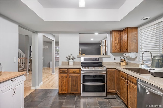 4028 S Atchison Way, Aurora, CO 80014 - kitchen with appliances with stainless steel finishes, light countertops, brown cabinetry, and a raised ceiling