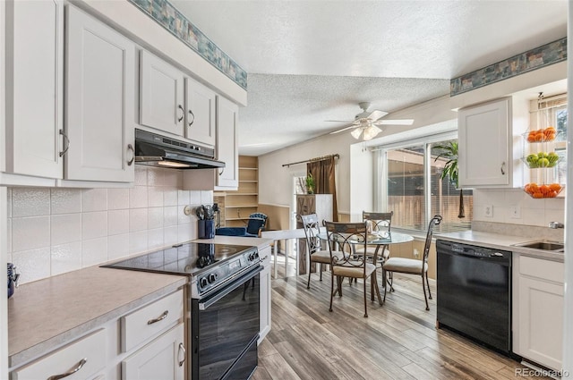 6735 E Lake Cir, Centennial, CO 80111 - kitchen featuring under cabinet range hood, a textured ceiling, black appliances, and a healthy amount of sunlight