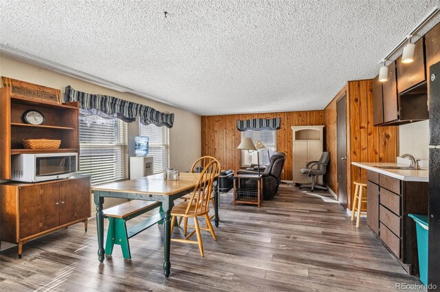 6735 E Lake Cir, Centennial, CO 80111 - dining space featuring wood finished floors, a textured ceiling, and wood walls