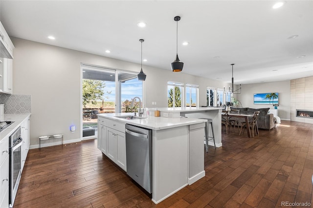 11023 Pastel Pt, Parker, CO 80134 - kitchen with dark wood-style flooring, appliances with stainless steel finishes, a sink, open floor plan, and white cabinetry