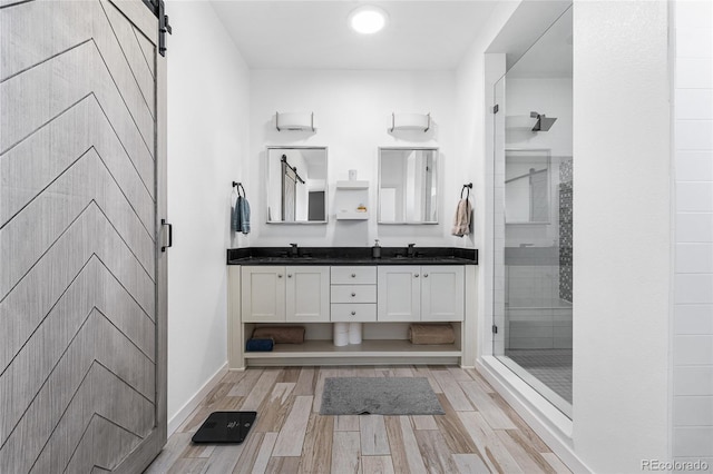 11023 Pastel Pt, Parker, CO 80134 - bathroom featuring wood finished floors, double vanity, a sink, and a stall shower