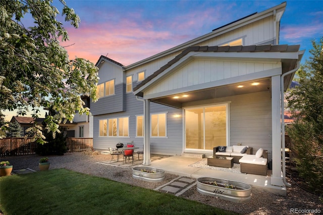 11023 Pastel Pt, Parker, CO 80134 - back of property at dusk with an outdoor hangout area, fence, a lawn, and a patio area