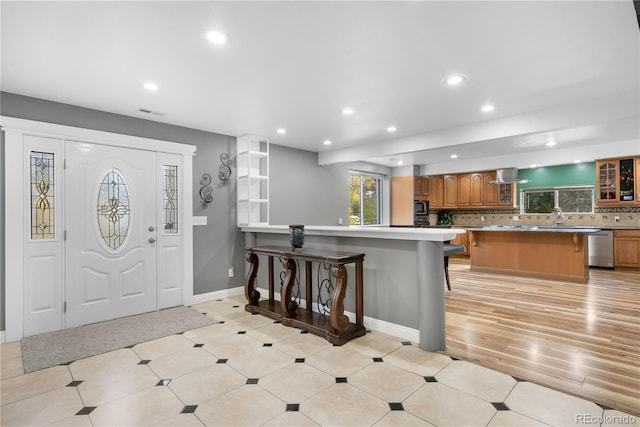 entryway with sink and light hardwood / wood-style flooring