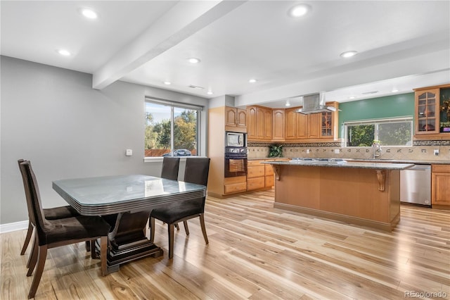 kitchen featuring a center island, appliances with stainless steel finishes, light hardwood / wood-style floors, and tasteful backsplash