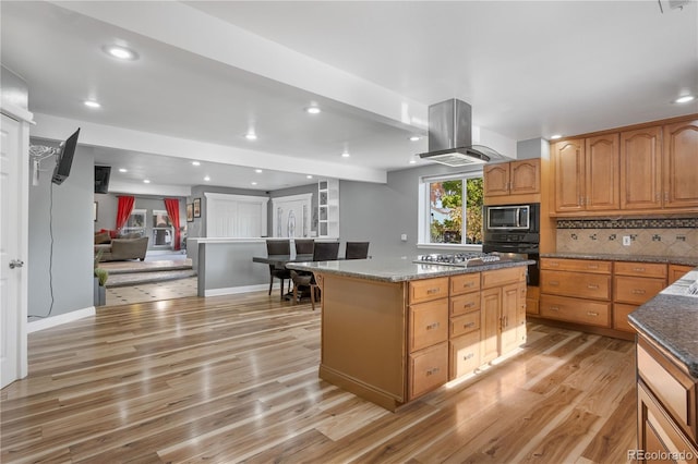 kitchen with island range hood, a center island, light hardwood / wood-style floors, stainless steel appliances, and decorative backsplash