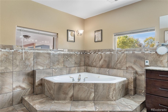 bathroom featuring vanity, a relaxing tiled tub, and tile walls