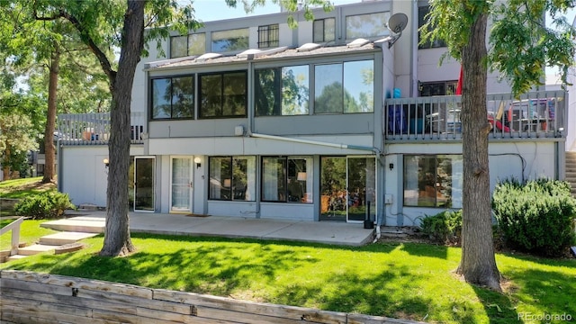 rear view of house featuring a patio area and a yard