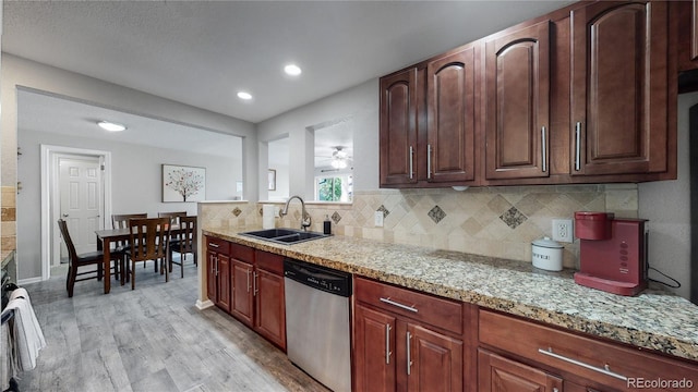 kitchen with ceiling fan, sink, light stone counters, light hardwood / wood-style flooring, and stainless steel dishwasher