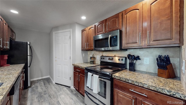 kitchen featuring tasteful backsplash, light hardwood / wood-style flooring, and stainless steel appliances