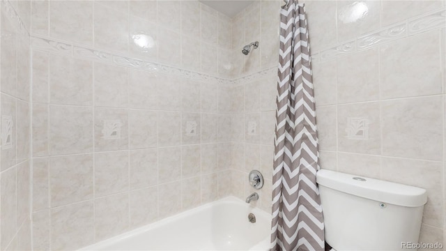 bathroom featuring shower / bath combination with curtain, tile walls, and toilet