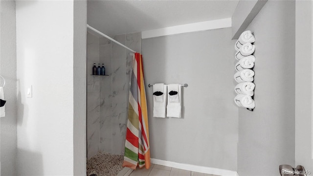 bathroom with tile patterned flooring and tiled shower