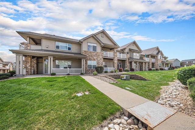10818 Cimarron St Unit 206, Firestone, CO 80504 - view of front of property with stone siding, a residential view, covered porch, and a front lawn