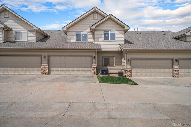 10818 Cimarron St Unit 206, Firestone, CO 80504 - townhome / multi-family property featuring stone siding, central AC, a shingled roof, and driveway
