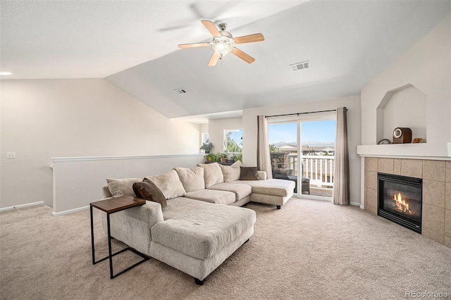 10818 Cimarron St Unit 206, Firestone, CO 80504 - living room with light carpet, ceiling fan, a tile fireplace, baseboards, and lofted ceiling