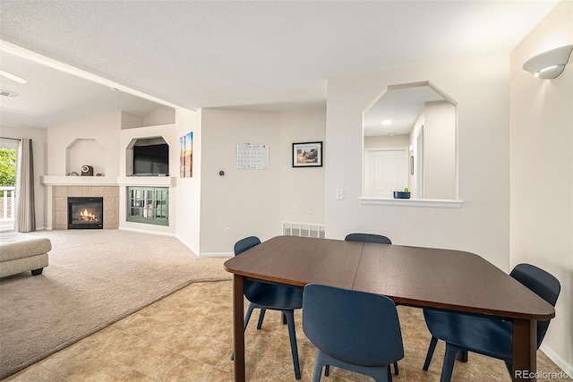 10818 Cimarron St Unit 206, Firestone, CO 80504 - tiled dining space featuring carpet floors, baseboards, and a tiled fireplace