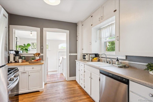 3622 Lowell Blvd, Denver, CO 80211 - kitchen featuring stainless steel appliances, white cabinets, light wood-style floors, and light countertops