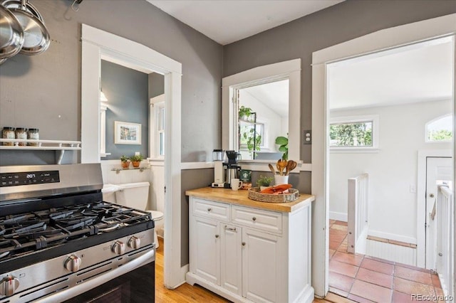 3622 Lowell Blvd, Denver, CO 80211 - kitchen with stainless steel gas range, white cabinetry, light countertops, and light tile patterned floors