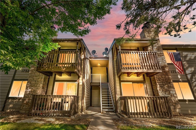 1758 S Pitkin Cir Unit A, Aurora, CO 80017 - view of front of home featuring a balcony, a chimney, and stone siding