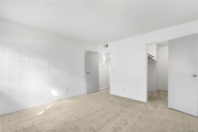 1758 S Pitkin Cir Unit A, Aurora, CO 80017 - unfurnished bedroom with carpet flooring, a textured ceiling, a spacious closet, and a closet