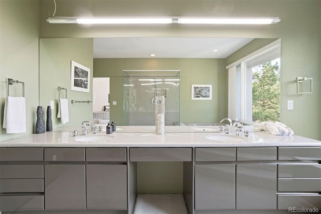 full bath with double vanity, a stall shower, and a sink